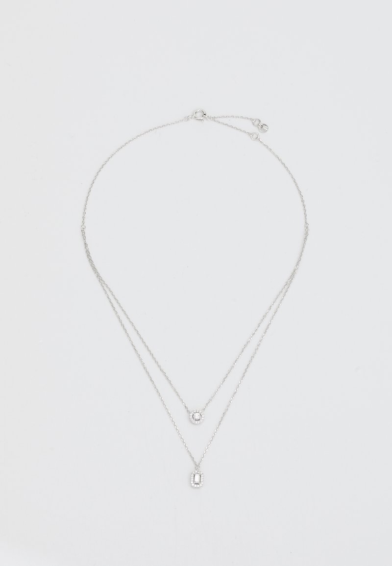 Collana a strati in argento con due catene. La catena superiore presenta un cristallo tondo, mentre la catena inferiore ha un pendente rettangolare allungato.