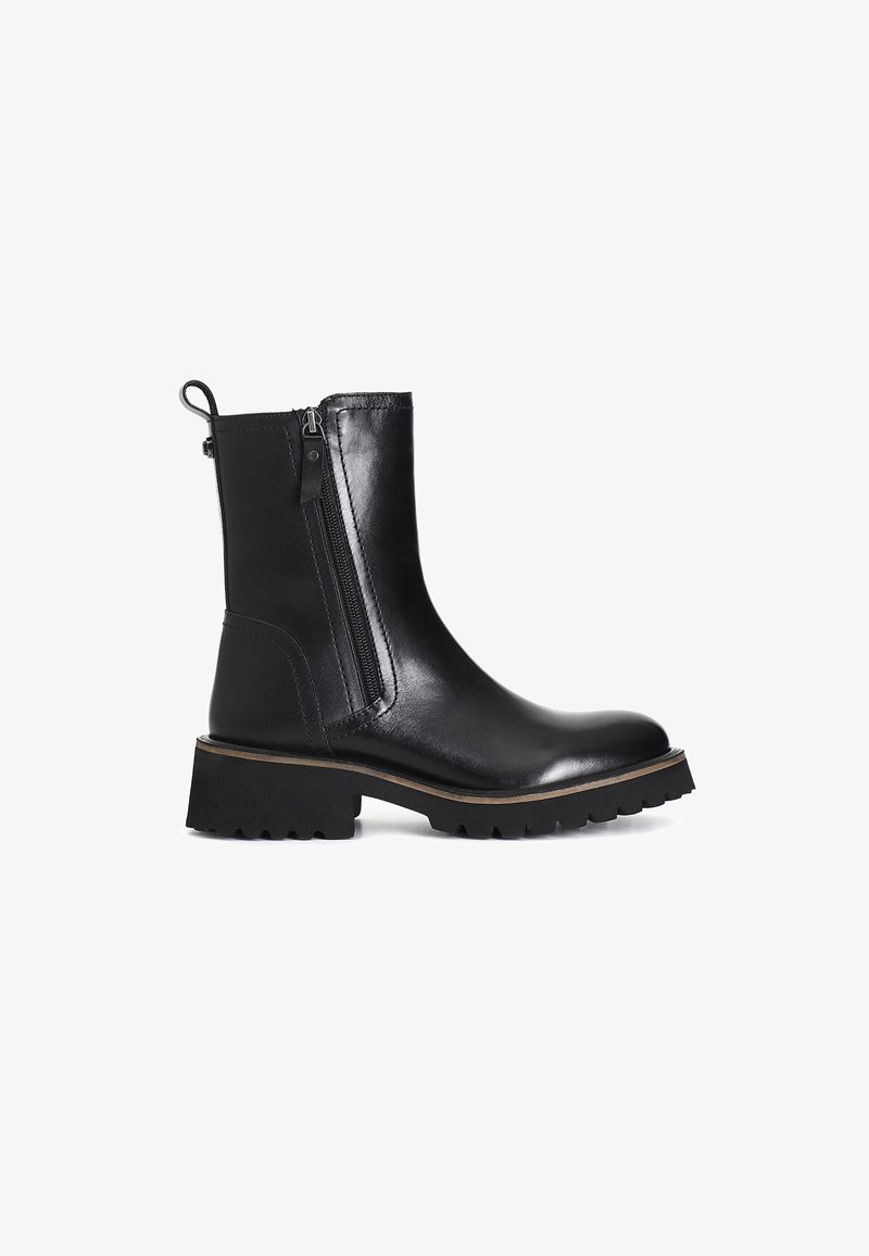 Botas negras hasta el tobillo hechas de cuero suave con una cremallera lateral, suela de goma gruesa y un tacón bajo para mayor estabilidad.