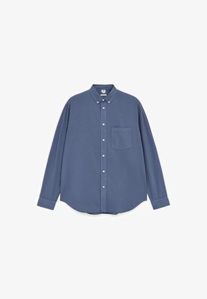 Mėlyna ilgomis rankovėmis marškiniai su sagomis, turintys sagomą apykaklę ir priekinio krūtinės kišenę, pateikti prieš baltą foną.