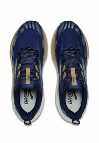 Marineblauwe hardloopschoenen met een gestructureerde mesh bovenzijde, gouden accenten, een gevoerde zool en platte veters. Voorzien van een logo op de tong en de binnenzool.