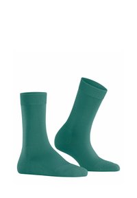 Grüne Baumwollsocken mit gerippten Bündchen. Sie haben eine glatte Textur und ein klassisches Crew-Längen-Design. Keine Muster oder auffälligen Akzente.