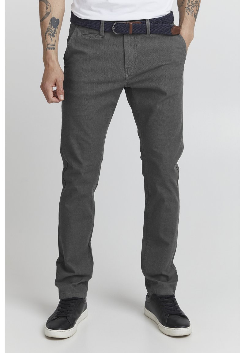 Pantalones de mezcla de algodón grises con un ajuste slim, que presentan un frente plano, bolsillos laterales y un cinturón tejido azul marino con un acento de cuero marrón.