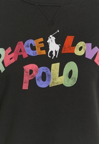 Zwarte sweatshirt met kleurrijke tekst "PEACE LOVE POLO" en een witte polo-speler afbeelding. Geribbelde textuur en ronde hals.