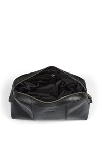 Svart lädernecessär med dragkedja upptill, med en texturerad yta och ett rymligt, fodrat inre med en ficka.