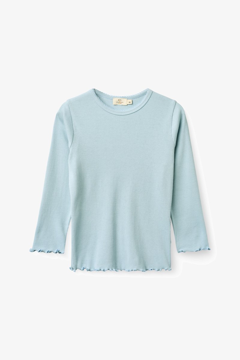 Chemise à manches longues côtelée bleu clair pour tout-petit avec bords festonnés aux manches, à l'ourlet et à l'encolure, présentation à plat sur fond blanc.