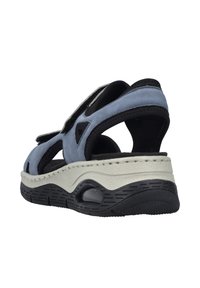 Sandale en suède bleu avec des accents noirs, design ouvert à l'avant, brides réglables, semelle épaisse blanche et noire avec des crampons et des détails d'amorti.