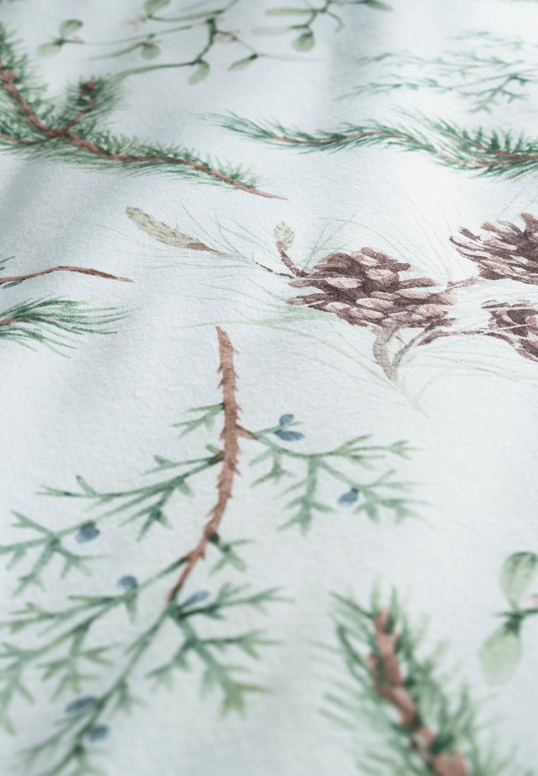 Stof met aquarelillustraties van den takken en dennenappels, in groene en bruine tinten op een zachte, lichtblauwe achtergrond.