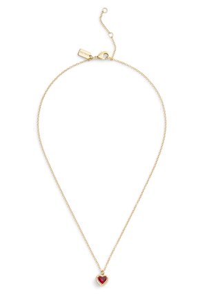 Gold chain necklace featuring a heart-shaped pendant with a red gemstone. Delicate links and a lobster clasp closure.