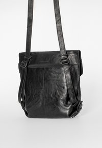 Musta nahkainen olkalaukku, jossa säädettävät hihnat ja etutasku vetoketjulla, esillä valkoista taustaa vasten.