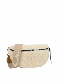 Bolso de felpa color crema con una superficie texturizada, cremallera negra y correa de hombro beige que presenta el nombre de la marca en cursiva.