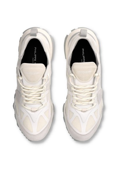 Baskets de sport blanches avec une surface texturée, des panneaux en mesh et des accents ton sur ton. Comprend des lacets épais et une conception à bout rond.