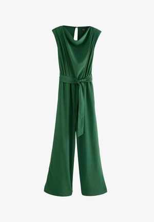 Zielony satynowy kombinezon z dekoltem typu cowl, bez rękawów, z paskiem w talii i szerokimi nogawkami. Szczegół z odkrytymi plecami.