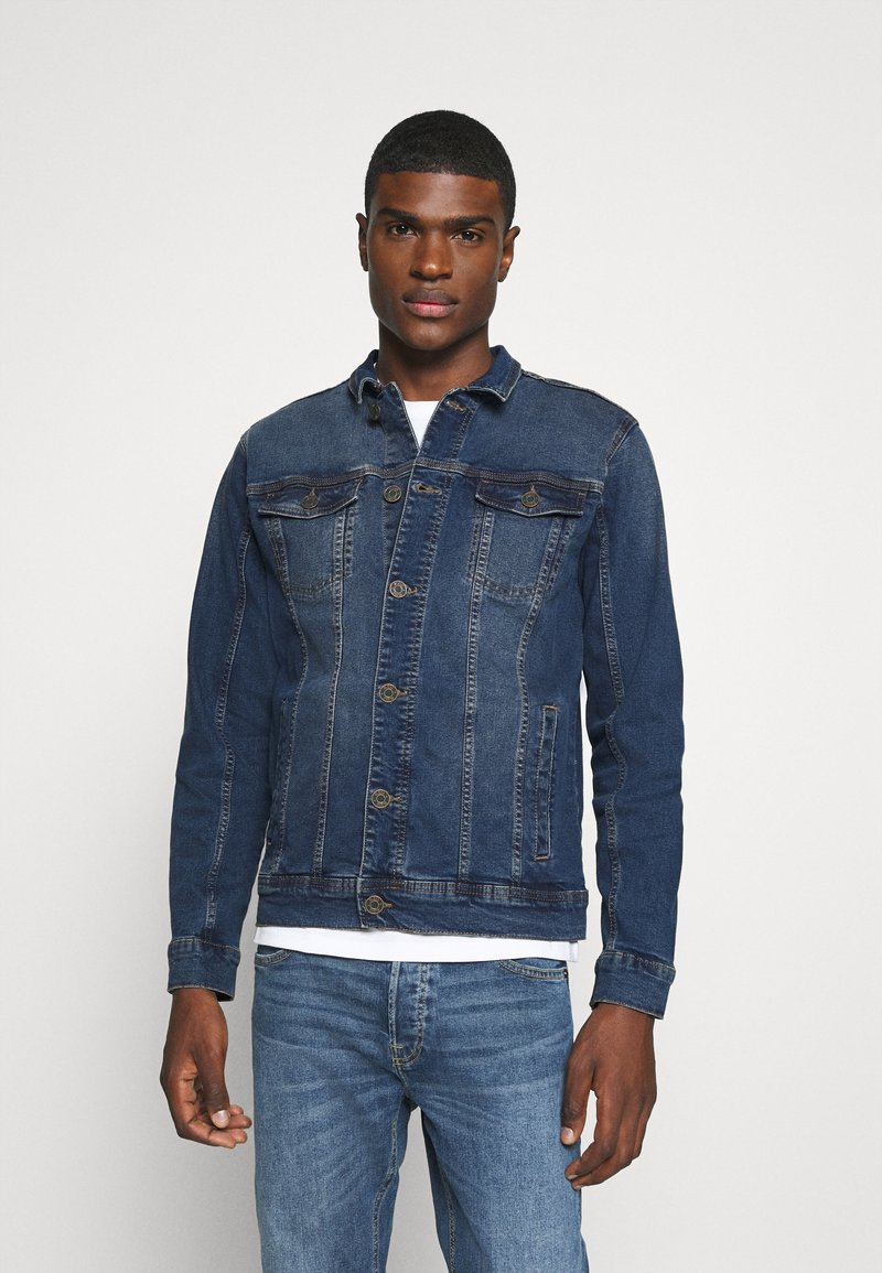 Denim jakna v temno modri barvi s klasičnim dizajnom, ki vključuje dva žepa na prsih, zapiranje na gumb in rahlo teksturirano tkanino.