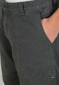 Gray cotton utility shorts featuring a front pocket, a button closure, and detailed stitching. The fabric has a smooth texture.