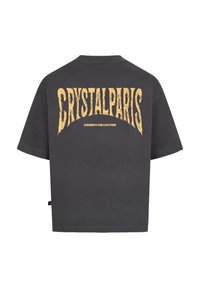 Tmavě šedé oversized tričko s texturovanou žlutou grafikou nápisem "CRYSTALPARIS" a "CHAMPS COLLECTION" na zadní straně. Krátké rukávy.