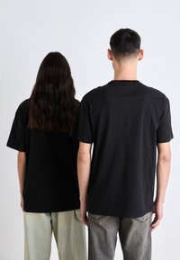 Tommy Jeans SIGNATURE TWIST TEE UNISEX - Camiseta estampada - black