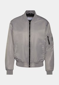 Giacca bomber grigia con una finitura liscia e lucida. Presenta una zip frontale, tasche laterali, e polsini ed orlo elasticizzati. Include una tasca con zip sulla manica.