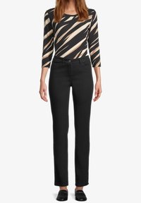 Svarta byxor med rak bendesign och framfickor, i kombination med en flerfärgad mönstrad topp med långa ärmar.