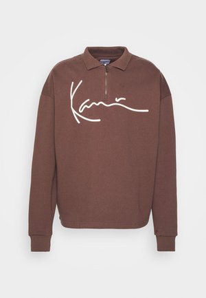 Brauner Reißverschluss-Pullover mit langen Ärmeln, der auf der Vorderseite ein weißes Signature-Logo trägt. Hergestellt aus einem weichen, strukturierten Stoff.