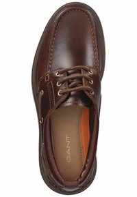 Braune Lederschuhe mit glatter Oberfläche, runder Zehenpartie, genähten Details und Messingösen für die Schnürsenkel. Mit einer hellbraunen Innensohle.