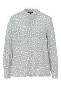 Chemise boutonnée gris clair en tissu lisse, ornée de motifs circulaires noirs et d'un col, avec des manches longues et des poignets boutonnés.