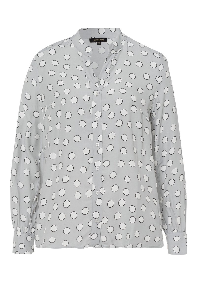Chemise boutonnée gris clair en tissu lisse, ornée de motifs circulaires noirs et d'un col, avec des manches longues et des poignets boutonnés.