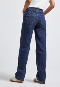 Dunkelblaue Denim-Jeans mit einem dehnbaren Bund, geradem Bein, zwei Gesäßtaschen und dezenten Nähdetails.
