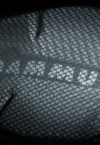 Svart nätfiber med ett hexagonmönster, med texten "MAMU" i en ljusare nyans integrerad i designen.