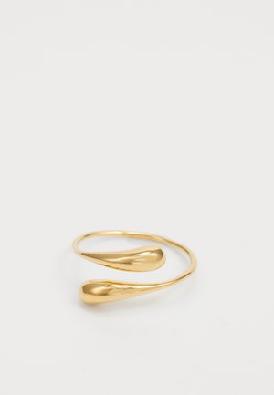 Gold-tone ring with a smooth, reflective surface, featuring a unique, curved design that wraps around with two pointed ends.