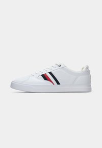 Adidași albi dintr-un material sintetic neted, cu vârf rotund, design cu șireturi și dungi pe părțile laterale în roșu și albastru închis. Talpă din cauciuc texturat.