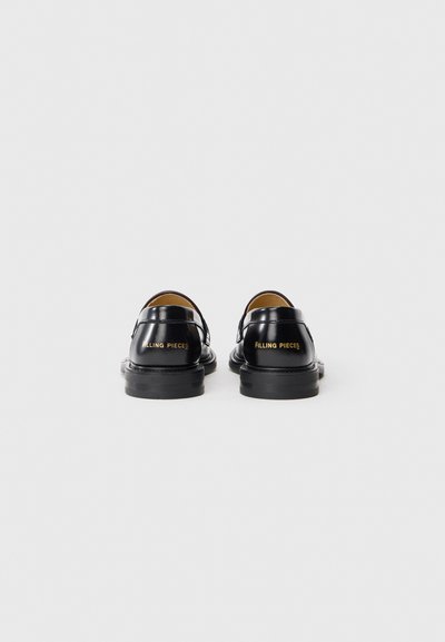 Čierne kožené topánky s lesklým povrchom, s členkovými popruhmi a zlatým logom "FILLING PIECES" na päte. Nízky gumový podpätok.