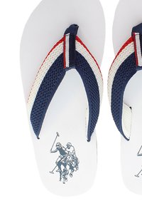 Siniset ja valkoiset flip-flopit punaisilla yksityiskohdilla, teksturoidut hihnat ja valkoiseen pohjaan printattu graafinen kuva kahdesta polo-pelaajasta.