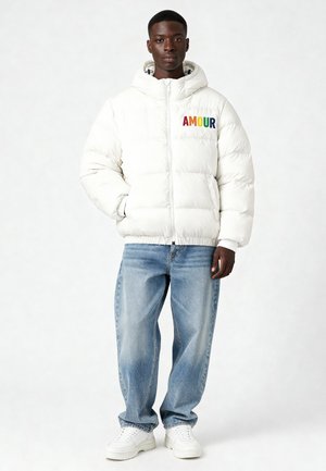 Giacca bianca imbottita con cappuccio, caratterizzata da ricamo multicolore "AMOUR". Abbinata a jeans azzurri e sneaker bianche.