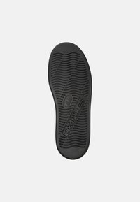 Sole in gomma nera con un motivo ondulato testurizzato, con il marchio "CAMPER" e bordi lisci per un design slanciato.