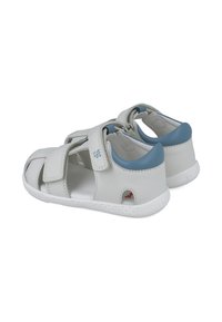 Sandalias de cuero blanco con acentos azules, diseño abierto, dos correas ajustables y suela de goma texturizada. Adecuadas para uso casual.