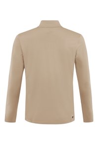 Chemise beige à manches longues avec un col haut, vue de dos, avec une petite étiquette noire près de l'ourlet inférieur côté droit.