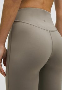 High-waisted, form-fitting leggings in a muted gray color, featuring a smooth texture and subtle stitching details.