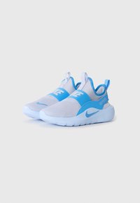 Jasnoszare i niebieskie sneakersy Nike na gumowej podeszwie, z elastycznym paskiem, uchwytami do zakładania i napisem "Just Do It" na pasku pięty, na białym tle.