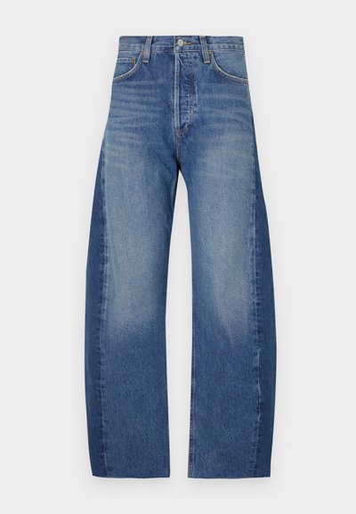 Denim teksad heledast tumsinise gradiendiga, rõhutades mugavat laia jalarakendust, viit taskut ja nähtavaid õmblustead.