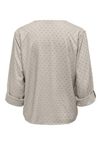 Blusa beige chiaro con maniche a tre quarti, design a pois testurizzati, orlo arrotondato e dettaglio con risvolto. Realizzata in tessuto morbido e leggero.