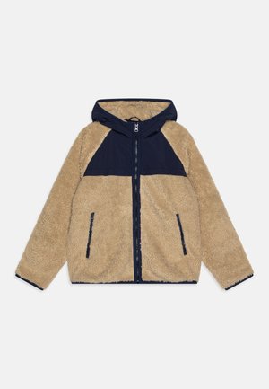 Beige Fleecejacke mit einer dunkelblauen Kapuze und Schulterpartie, Reißverschluss, zwei Fronttaschen und dunkelblauen Besatz entlang der Bündchen und am Saum.
