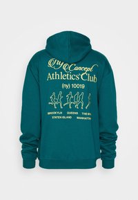 Błękitna bluza z kapturem z beżowym napisem "Concept Athletics Club (ny) 10019" oraz figurami biegaczy, wymieniającymi Brooklyn, Queens, Staten Island, Manhattan.