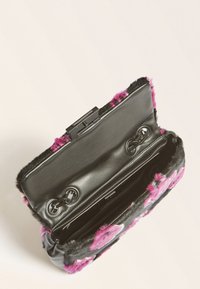 Borsa nera con un esterno in pelliccia texturizzata e accenti rosa. Chiusura a scatto e dettagli in catena all'interno, che mettono in mostra una fodera interna liscia.