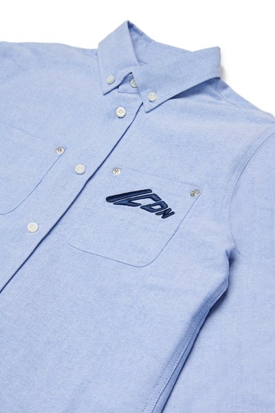 Camicia button-up azzurra chiara realizzata in tessuto testurizzato, con colletto strutturato, due tasche frontali e un logo ricamato blu scuro.