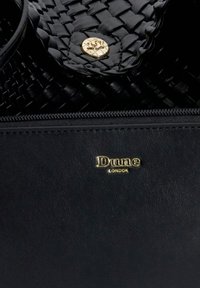 Zwarte leren handtas met een geweven textuur, gouden hardware en een gouden logo "Dune LONDON" op de voorkant gedrukt. Inclusief ritssluiting.