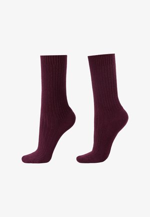 Bordeaux ribbel sokken met een gladde textuur, met een lengte tot halverwege de kuit en een aansluitend ontwerp rond de enkel. Rekbaar materiaal voor comfort.