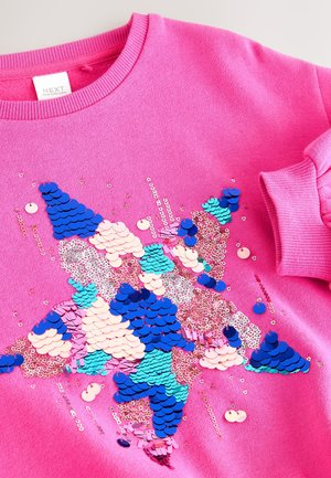 Rosa sweatshirt med en stjärndesign gjord av flerfärgade paljetter i blått, rosa och turkos, med glittrande detaljer över hela.
