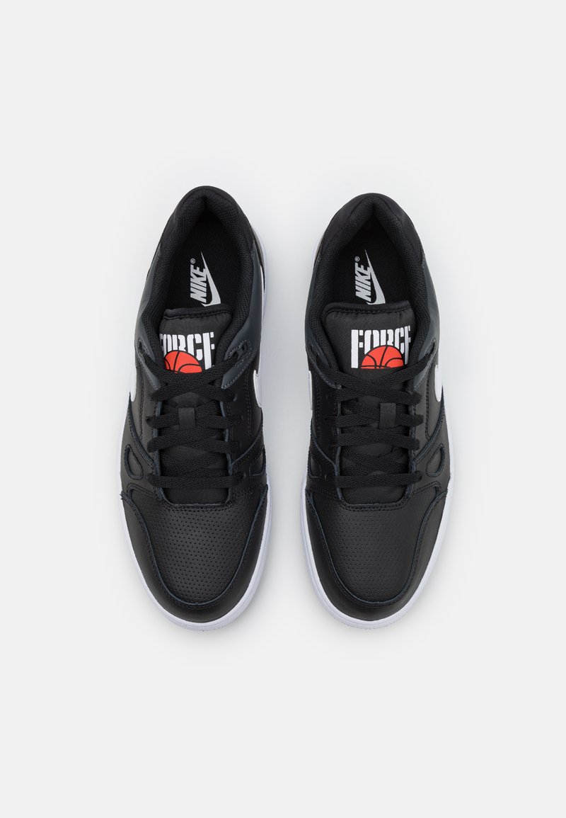 Scarpe da basket sintetiche nere con tomaia perforata, swoosh Nike bianco e logo rosso/nero sulla linguetta. Suola in gomma bianca.