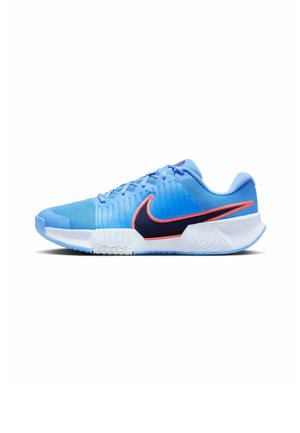 Chaussure de sport bleu clair avec semelle blanche, swoosh Nike noir et orange, tige en mesh et lacets, vue de côté sur fond blanc.