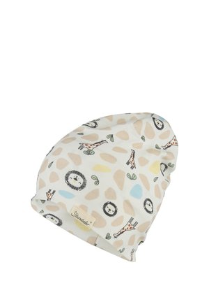 Soft white baby hat with printed brown giraffes, smiling lion faces, and abstract beige, yellow, and blue shapes, featuring a small fabric brand tag.